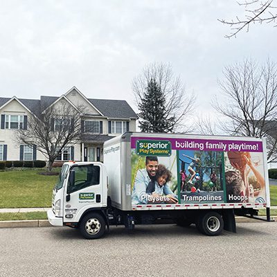 A Superior Play Systems truck making a home delivery