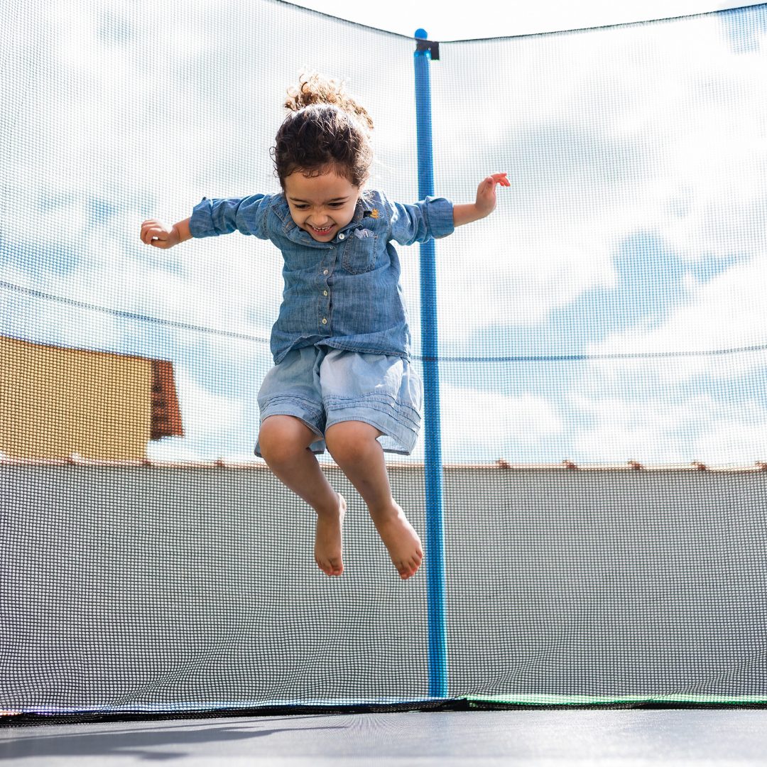 Girl smiling while jumping on a trampoline