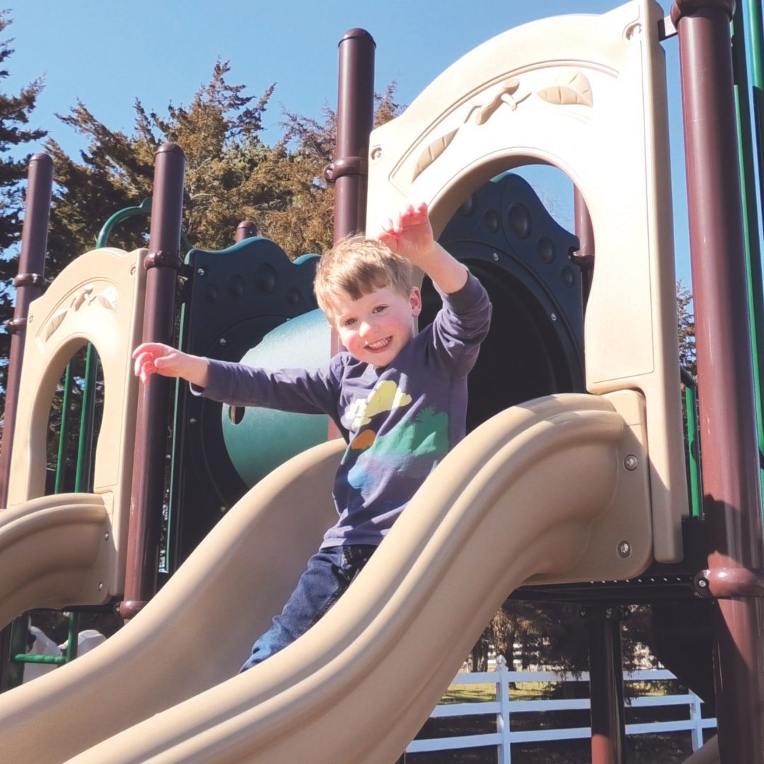 boy on slide of a Commercial Play System