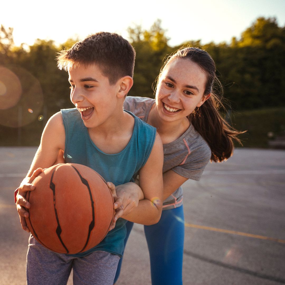 brother and sister playing basketball