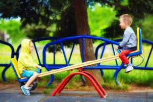 two children playing on a seesaw