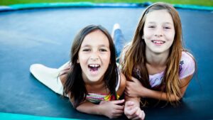 two girls smiling on trampoline