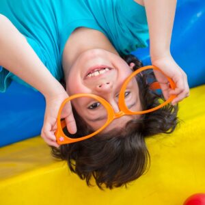 smiling kid wears clown glasses 