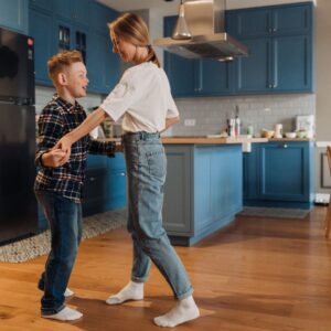 kids hold hands while dancing in kitchen 