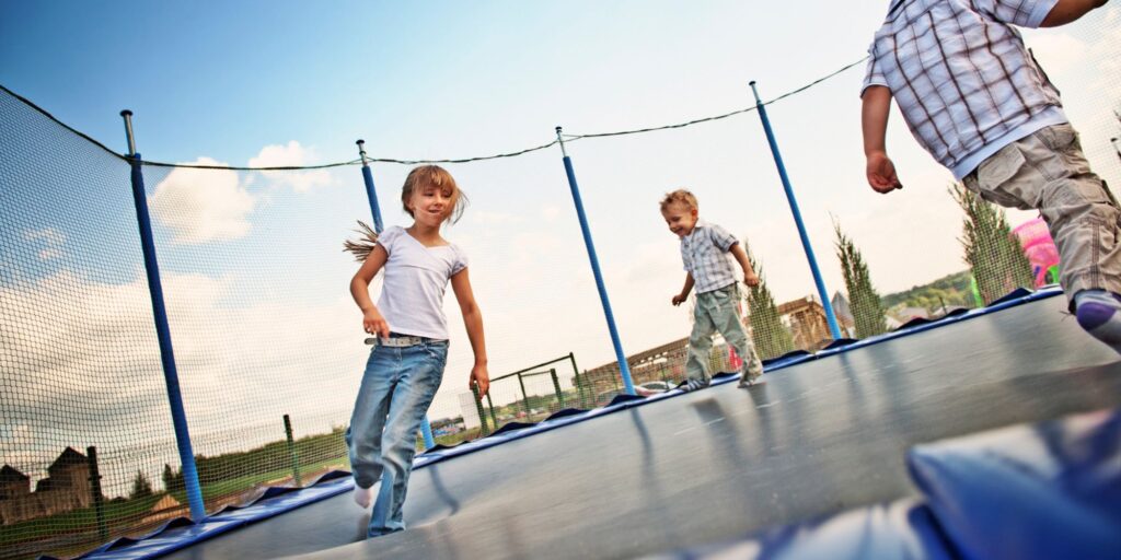 kids run around trampoline with enclosed sides