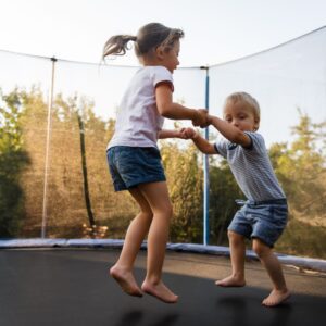 kids hold hands jumping together 